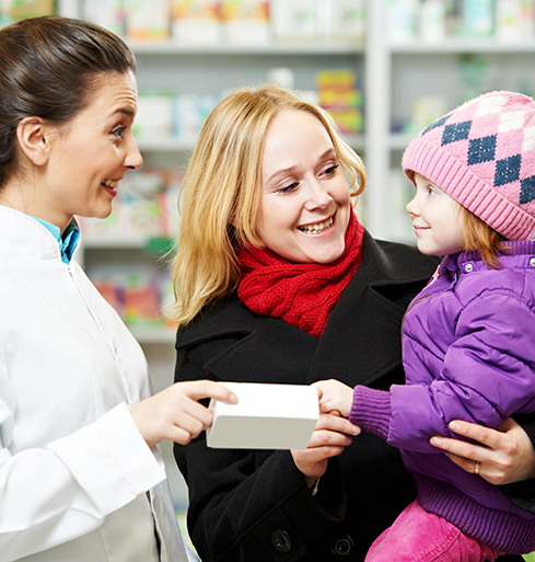 Young mother holding her baby while friendly Best Value Pharmacies representive interacts.